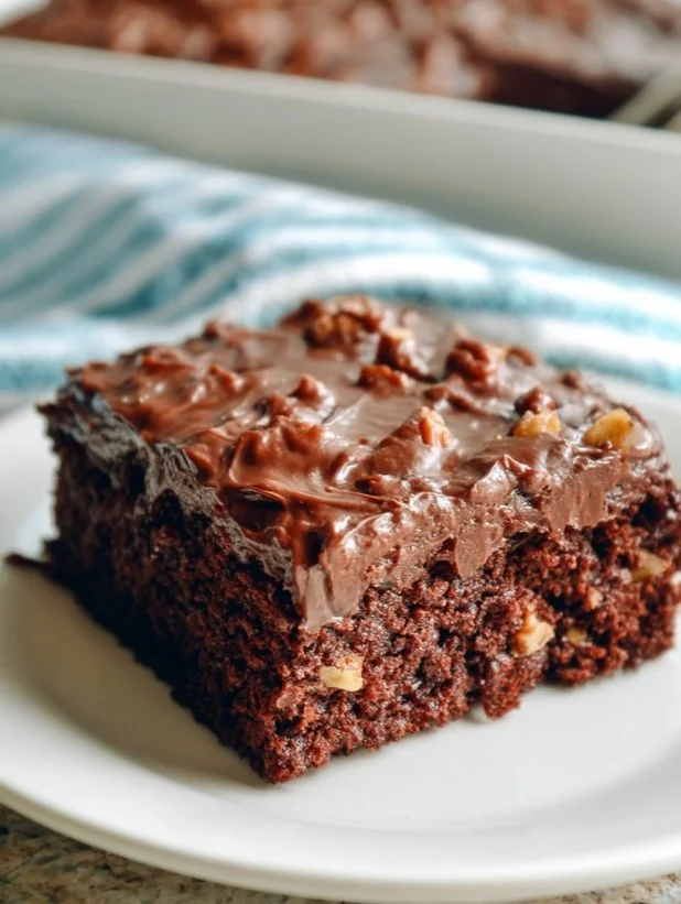 Delicious Texas Sheet Cake topped with chocolate icing and walnuts.