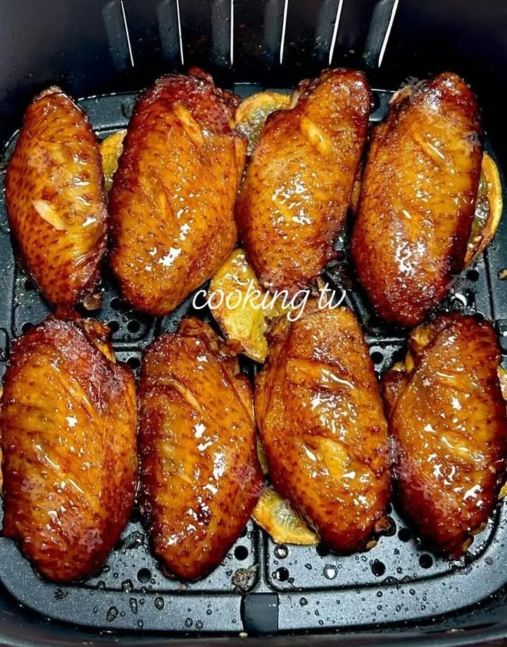 Crispy air fryer lemon chicken wings garnished with fresh herbs