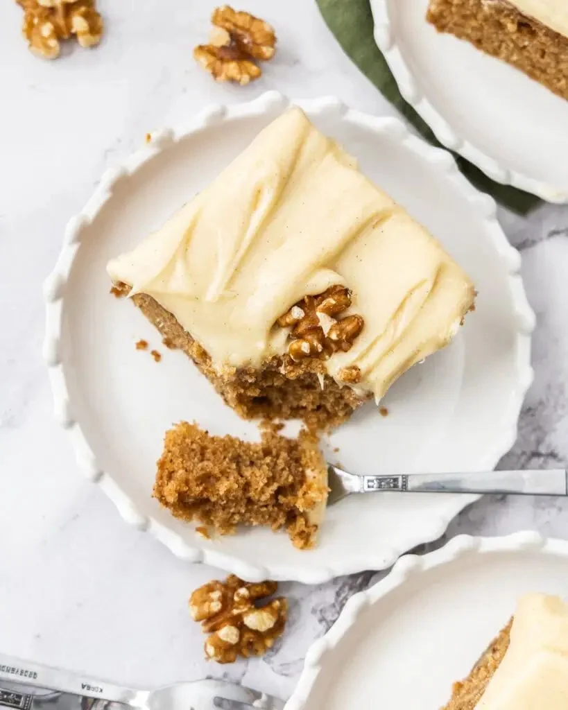 Delicious homemade applesauce cake with frosting on a plate.