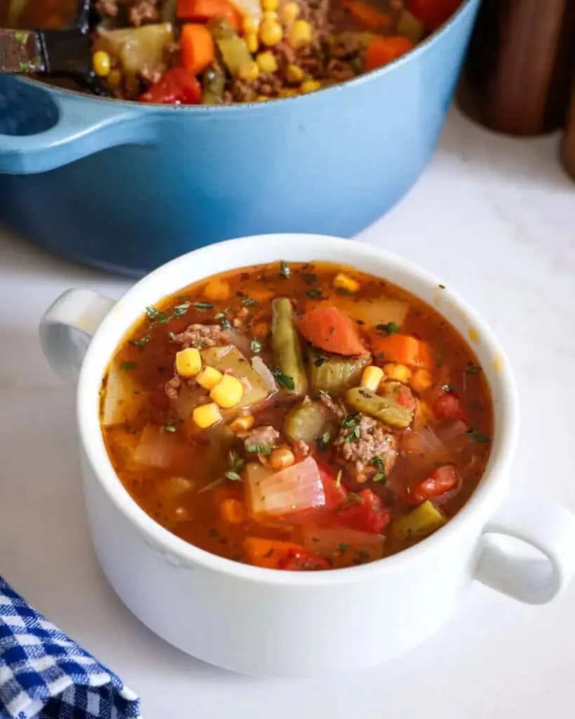 Bowl of easy hamburger soup garnished with fresh herbs