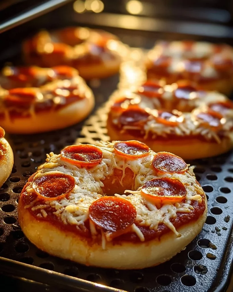 Homemade air fryer pizza bagels topped with cheese and pepperoni.